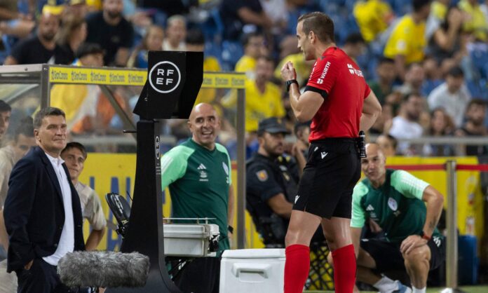 Un árbitro revisando imágenes del VAR en un partido.