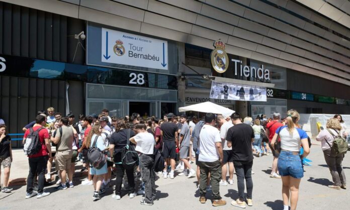 Varias personas guardan cola para realizar el Tour del estadio Santiago Bernabéu durante el verano de 2025.